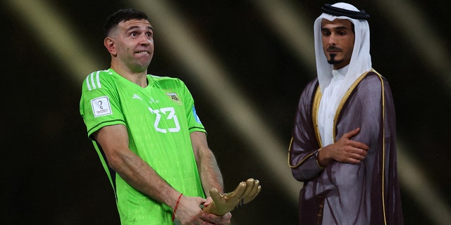 Argentina's Emiliano Martinez reacts after receiving the Golden Glove award after the World Cup final.