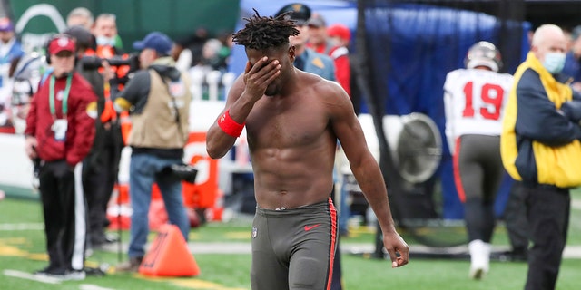 Tampa Bay Buccaneers wide receiver Antonio Brown wipes his face as he leaves the field after throwing his equipment into the stands while his team is on offense during the third quarter of an NFL football game against the New York Jets, Sunday, Jan. 2, 2022, in East Rutherford, New Jersey. 