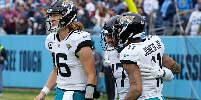 Jacksonville Jaguars tight end Evan Engram (17) is congratulated by teammates Trevor Lawrence (16) and Marvin Jones Jr. (11) after scoring during the first half of a game against the Tennessee Titans Dec. 11, 2022, in Nashville. 