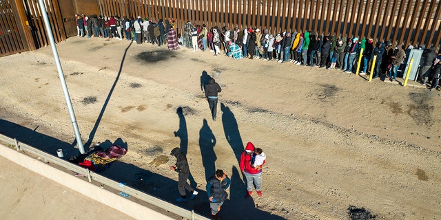 An aerial view of immigrants lining up next to the U.S.-Mexico border fence after spending the night outside on December 22, 2022 in El Paso, Texas.