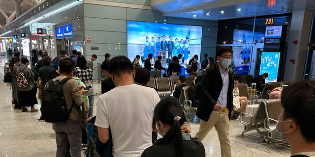 Passengers prepare to board a flight at the airport in north-central China's Jiangxi province on Nov. 1, 2022. The Chinese government said Tuesday, Dec. 27 it will start issuing new passports as it dismantles anti-COVID travel barriers, setting up a potential flood of millions of tourists out of China for next month's Lunar New Year holiday. 