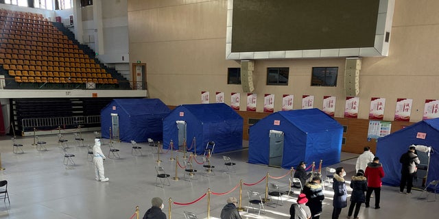 People line up at a makeshift fever clinic set up inside a stadium amid the COVID-19 outbreak in Beijing, China, Dec. 19, 2022.