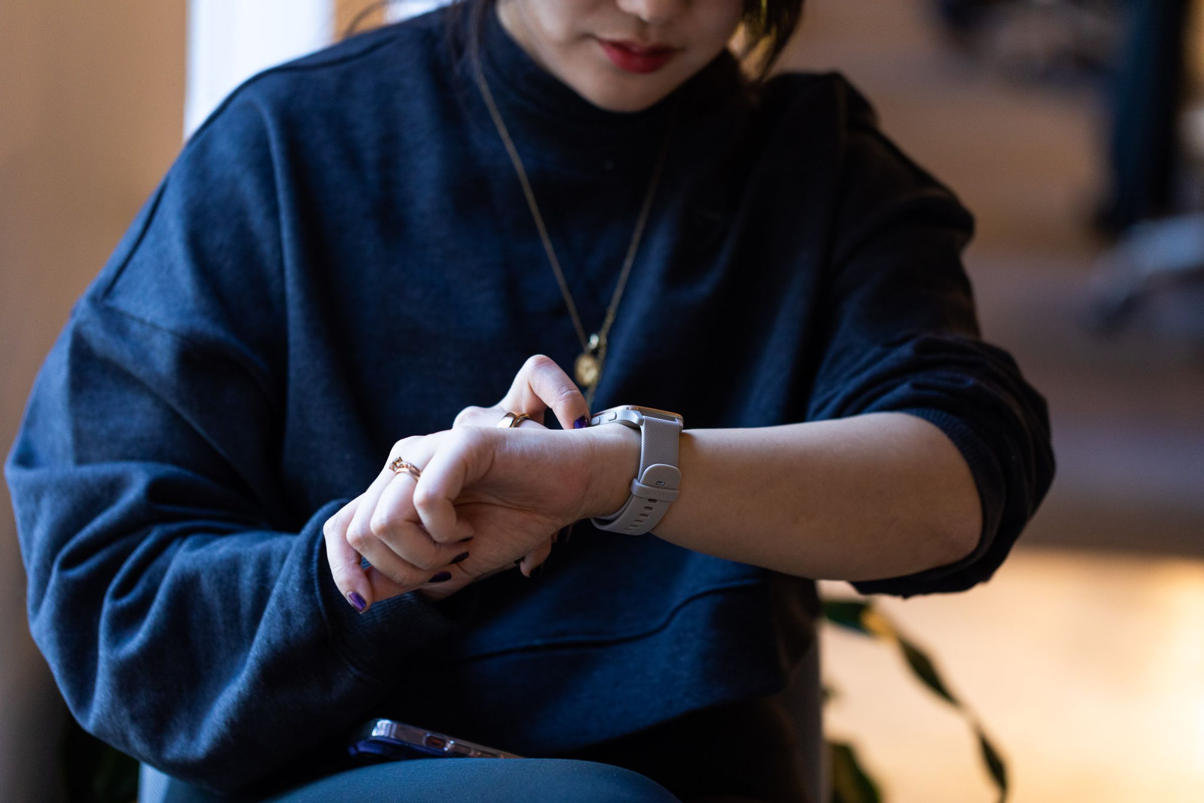 Woman looking at Venu Sq 2 on wrist.