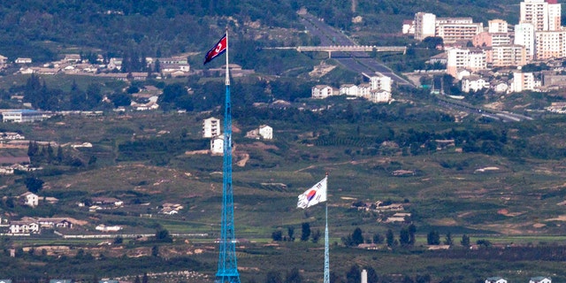 Flags of North Korea, rear, and South Korea, front, flutter in the wind as pictured from the border area between two Koreas in Paju, South Korea. 