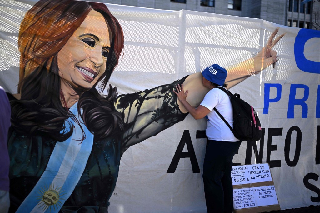 A supporter of Argentina's Vice-President Cristina Fernandez kisses her image on a banner hung outside the Courthouse Comodoro Py in Buenos Aires on Dec. 6, 2022.