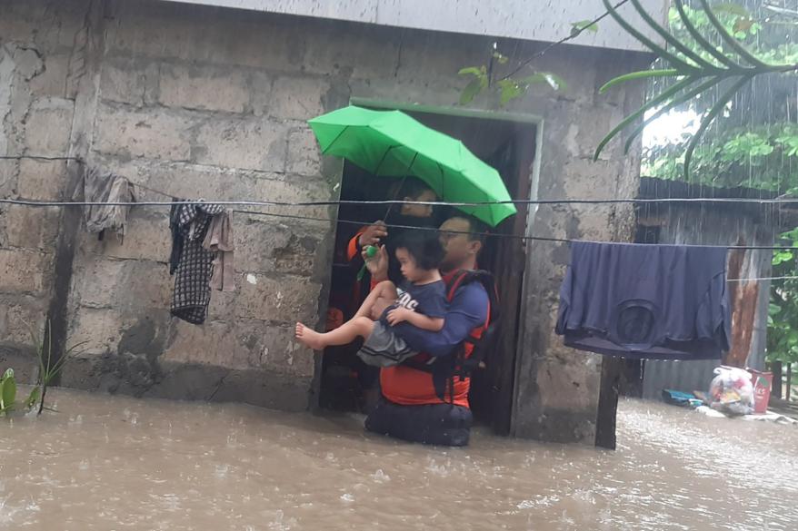 Philippine Coast Guard rescuers evacuates a child from a flooded area in Ozamiz City, Philippines.