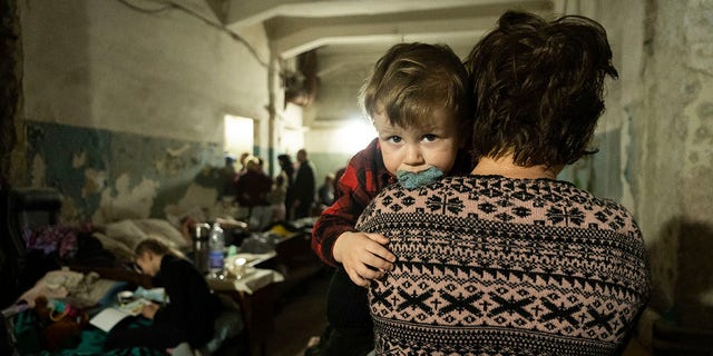 A woman holds a child in an improvised bomb shelter in Mariupol, Ukraine, Monday, March 7, 2022. 