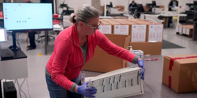 An election worker boxes tabulated ballots inside the Maricopa County Recorders Office, Wednesday, Nov. 9, 2022, in Phoenix.