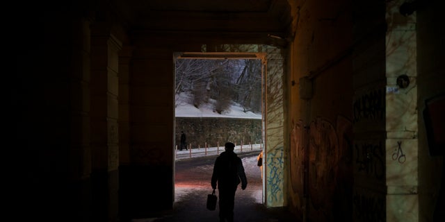 A man walks during a power outage in Kyiv, Ukraine, Thursday, Dec. 15, 2022.