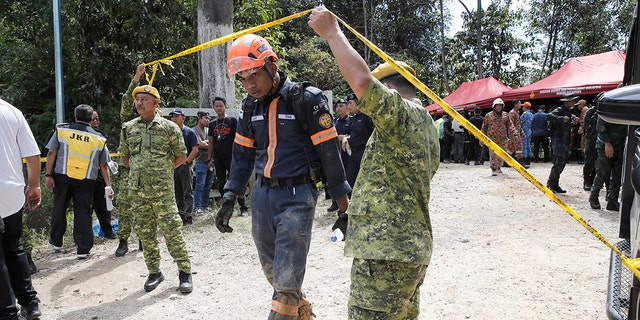 Rescue team gather at a control post near the site of a landslide at an organic farm in Batang Kali, Malaysia, Friday, Dec. 16, 2022. Dozens of Malaysians were believed to have been at a tourist campground in Batang Kali, outside the capital of Kuala Lumpur, when the incident occurred, said a district police chief.