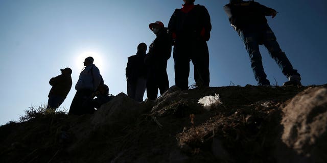 Migrants stand near the U.S.-Mexico border in Ciudad Juarez, Mexico, Monday, Dec. 19, 2022. 