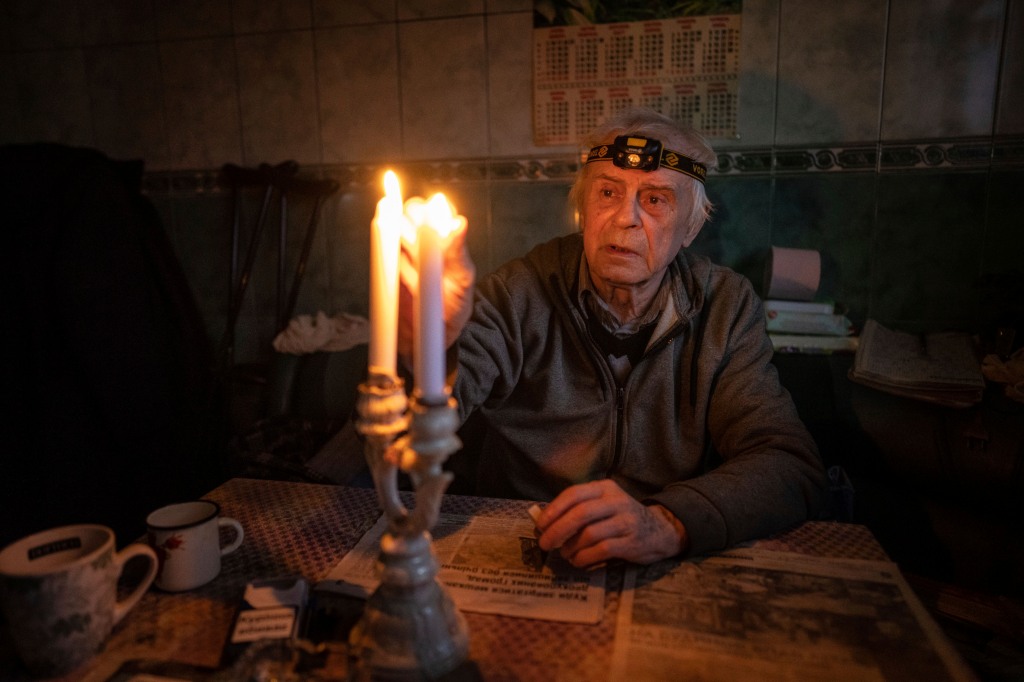 A Ukrainian man, Volodymyr Dubrovsliy, lights a candle in his house. Dubrovsliy has been living with no electricity for more than four months.