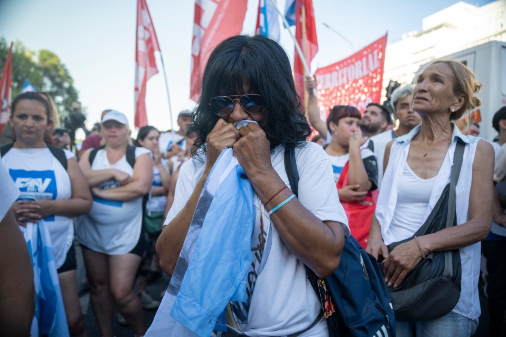 A supporter of Argentine Vice President Cristina Fernandez cries while holding an Argentine flag after hearing the verdict outside the federal court building in Buenos Aires, Argentina on Dec. 6, 2022.