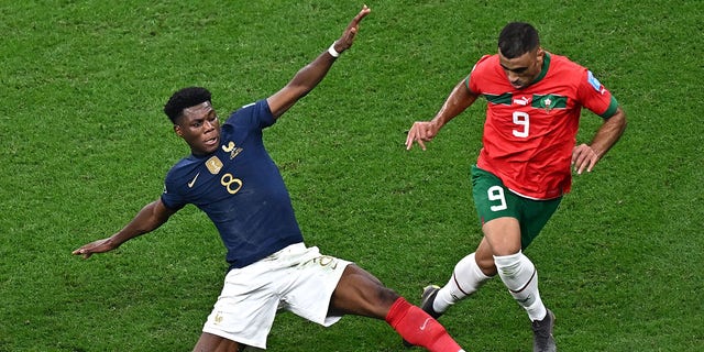 French midfielder Aurélien Tchouaméni (8) and Moroccan forward Abderrazak Hamdallah (9) fight for the ball during a Qatar 2022 World Cup semifinal match at Al-Bayt Stadium in Al Khor, north of Doha, Dec. 14, 2022.