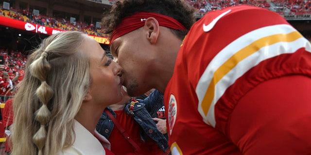 Patrick Mahomes #15 of the Kansas City Chiefs kisses his wife, Brittany Matthews, before the game against the Los Angeles Chargers at Arrowhead Stadium on September 15, 2022 in Kansas City, Missouri.