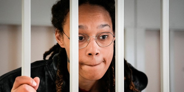 WNBA star and two-time Olympic gold medalist Brittney Griner speaks to her lawyers standing in a cage at a courtroom prior to a hearing, in Khimki just outside Moscow, July 26, 2022. 