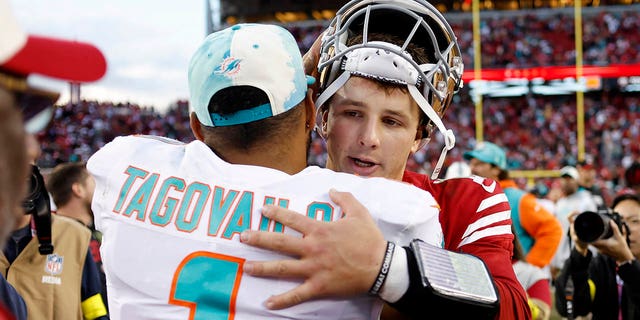 Miami Dolphins quarterback Tua Tagovailoa, #1, hugs San Francisco 49ers quarterback Brock Purdy after an NFL football game in Santa Clara, California, Sunday, Dec. 4, 2022. 