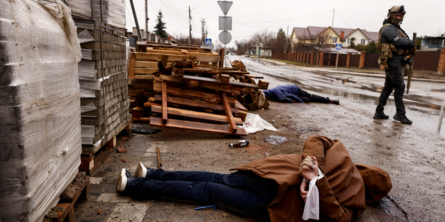 A body with hands bound by white cloth, who according to residents was shot by Russian soldiers, lies in the street in Bucha, Ukraine, on Sunday.