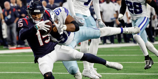 Houston Texans wide receiver Chris Moore (15) is stopped short of the goal line by Dallas Cowboys defensive end Carlos Watkins (91) during the second half, Sunday, Dec. 11, 2022, in Arlington, Texas.