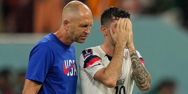 Head coach Gregg Berhalter of the United States, left, walks with Christian Pulisic after the World Cup round of 16 soccer match between the Netherlands and the United States, at the Khalifa International Stadium in Doha, Qatar, Saturday, Dec. 3, 2022. 