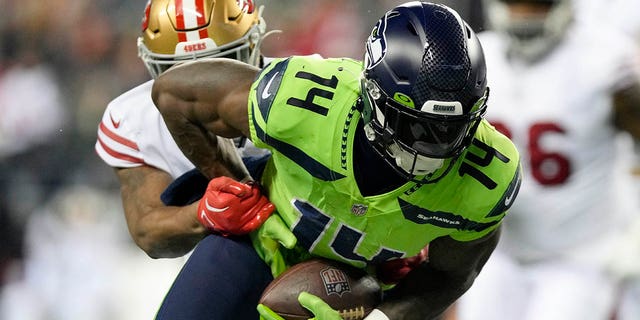 DK Metcalf, #14 of the Seattle Seahawks, carries the ball against the San Francisco 49ers during the second quarter of the game at Lumen Field on Dec. 15, 2022 in Seattle.