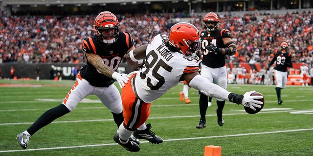 Cleveland Browns' David Njoku (85) reaches for a touchdown against Cincinnati Bengals' Jessie Bates III (30) during the second half of an NFL football game, Sunday, Dec. 11, 2022, in Cincinnati.