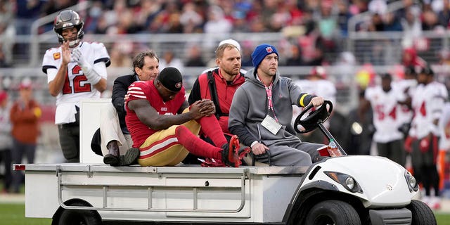 Tampa Bay Buccaneers quarterback Tom Brady, top left, reacts as San Francisco 49ers wide receiver Deebo Samuel, middle, is carted off the field during the first half in Santa Clara, California, Sunday, Dec. 11, 2022.