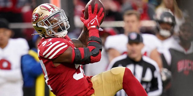 San Francisco 49ers linebacker Dre Greenlaw, right, intercepts a pass during the second half in Santa Clara, California, Sunday, Dec. 11, 2022.