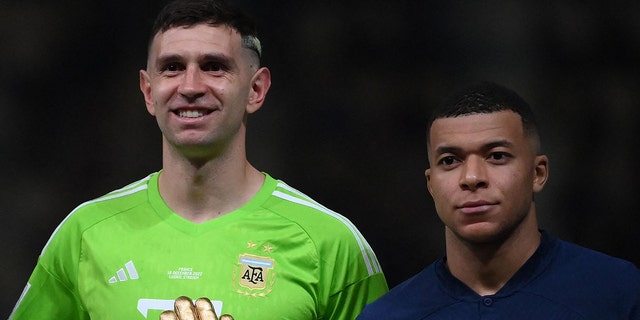 Argentina's Emiliano Martinez and France's Kylian Mbappe pose after awards during the Qatar World Cup trophy ceremony.