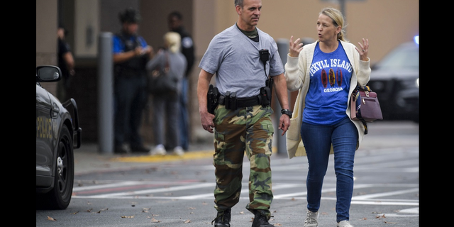 A police officer speaks to a woman outside the Georgia Walmart store following the shooting on Wednesday, Dec. 7.