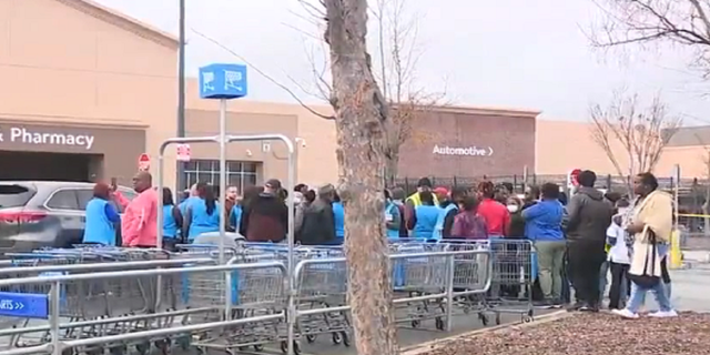 Walmart employees and customers are seen gathered outside the store in Marietta, Georgia, after it was evacuated.