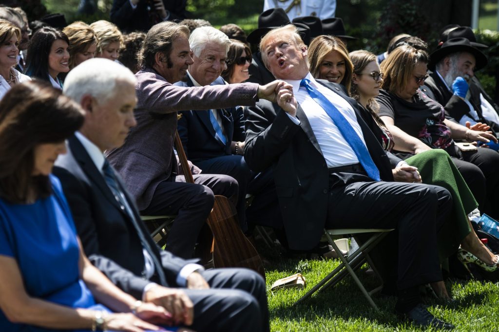 Former President Donald J. Trump reaches back to Jonathan Cain during a prayer as they participate in a National Day of Prayer Service in the Rose Garden at the White House on Thursday, May 2, 2019, in Washington, DC.