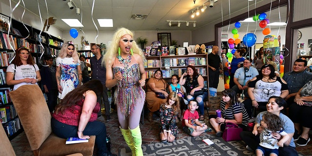 Drag queens Athena Kills, center, and Scalene Onixxx arrive to awaiting adults and children for Drag Queen Story Hour at Cellar Door Books in Riverside, California.