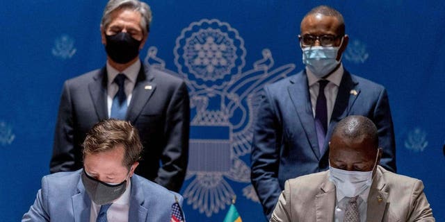 U.S. Secretary of State Antony Blinken (background L) and Senegal's Minister of Economy, Planning and International Cooperation Amadou Hott (background R) watch ABD Group CEO John Nevergole (L) and Ageroute Director General Ibrahima Ndiaye (R) sign an agreement during a commercial diplomatic event with U.S. companies and the government of Senegal at the Radisson Blu Hotel in Dakar, on November 20, 2021.