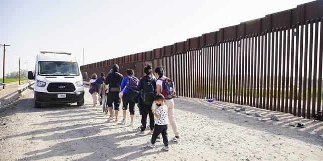 Asylum seekers board a CBP transport van after entering the United States in Yuma Arizona., May 20, 2022 