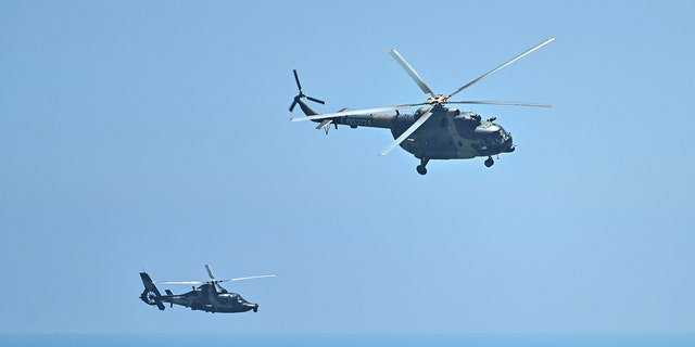 Chinese military helicopters fly past Pingtan island, one of mainland China's closest point from Taiwan, in Fujian province on August 4, 2022, ahead of massive military drills off Taiwan following US House Speaker Nancy Pelosi's visit to the self-ruled island. 