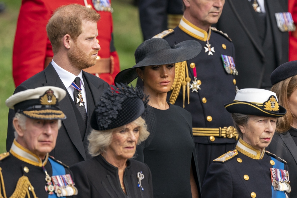 Prince Harry and Meghan standing behind King Charles and Queen Camilla at Queen Elizabeth II's funeral in September.