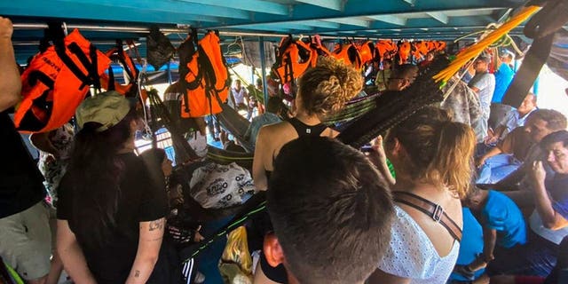 Foreign and Peruvian tourist wait in the boat where they have been detained at the Cuninico community in Loreto, north of Peru, on November 4, 2022. - Indigenous people in Peru's Amazon detained a group of foreign and Peruvian tourists traveling on a river boat to protest the lack of government aid following an oil spill in the area, local media reported Thursday. 