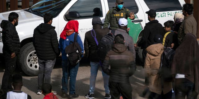 A border patrol agent communicates with illegal immigrants after they entered the U.S. near Tijuana, Mexico in November.