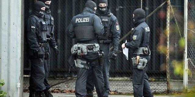 08 December 2022, Karlsruhe: Masked policemen outside the Federal Supreme Court in Karlsruhe, where those arrested in raids against a group planning a coup d'état in Germany are testifying. 