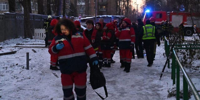 Rescuers gather close to a partially destroyed administrative building after a drone strike on the Ukrainian capital Kyiv on Dec. 14, 2022.