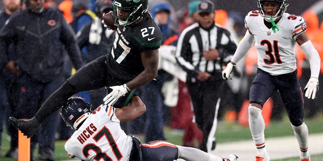 Zonovan Knight (27) of the New York Jets leaps over Elijah Hicks (37) of the Chicago Bears in the second half of a game at MetLife Stadium Nov. 27, 2022, in East Rutherford, N.J. 