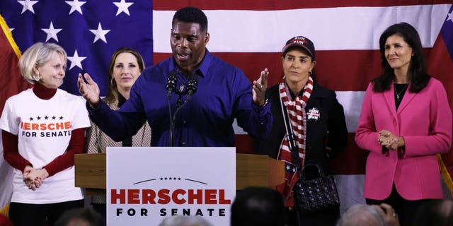 Georgia Republican Senate nominee Herschel Walker speaks as (L-R) Republican National Committeewoman for Georgia Ginger Howard, Republican National Committee Chair Ronna McDaniel, Walker’s wife Julie Blanchard and former U.S. Ambassador to the U.N. Nikki Haley listen during a campaign rally on December 5, 2022 in Kennesaw, Georgia.