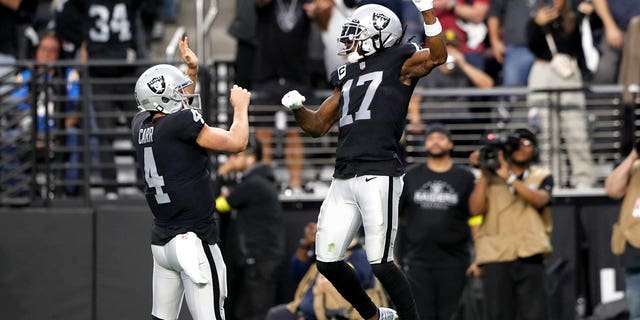 Wide receiver Davante Adams (17) of the Las Vegas Raiders celebrates with quarterback Derek Carr (4) after scoring a touchdown in the third quarter against the Los Angeles Chargers at Allegiant Stadium Dec. 4, 2022, in Las Vegas. 