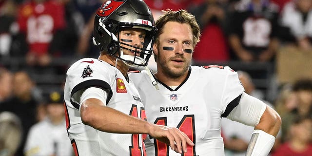 Tom Brady, #12 of the Tampa Bay Buccaneers, talks with Blaine Gabbert, #11, prior to a game against the Arizona Cardinals at State Farm Stadium on Dec. 25, 2022 in Glendale, Arizona. 