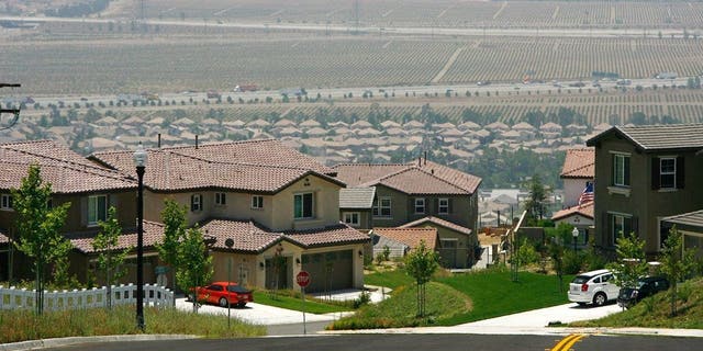 A gated community housing project overlooks a rural landscape that is being rapidly converted into a vast suburb as a construction boom continues in San Bernardino County.