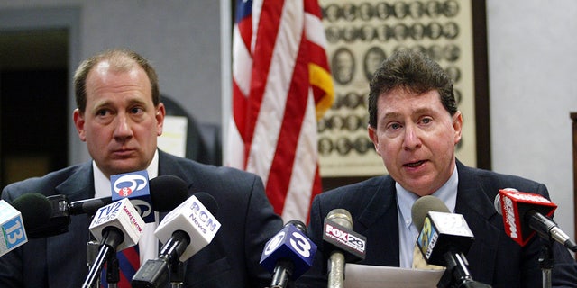 Northhampton County Coroner Zachery Lysek, left, and District Attorney John Morganelli talk about charges against nurse Charles Cullen, "The Angel of Death," who admitted using a syringe filled with stolen digoxin to kill dozens of patients as they lay in their beds at St. Luke's Hospital in Bethlehem, Pennsylvania.