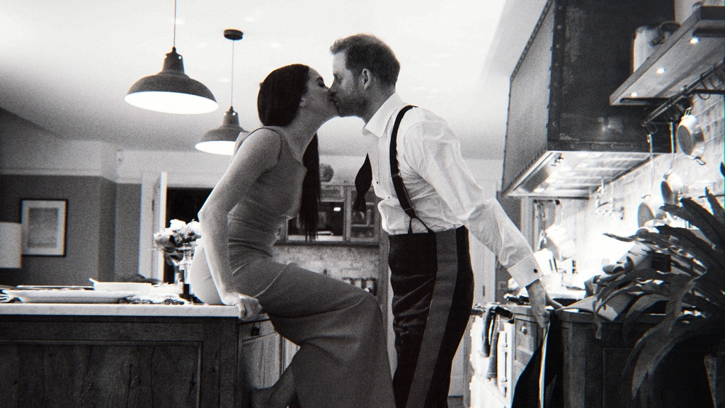 Prince Harry and Meghan share a kiss in a still from the Netflix program.