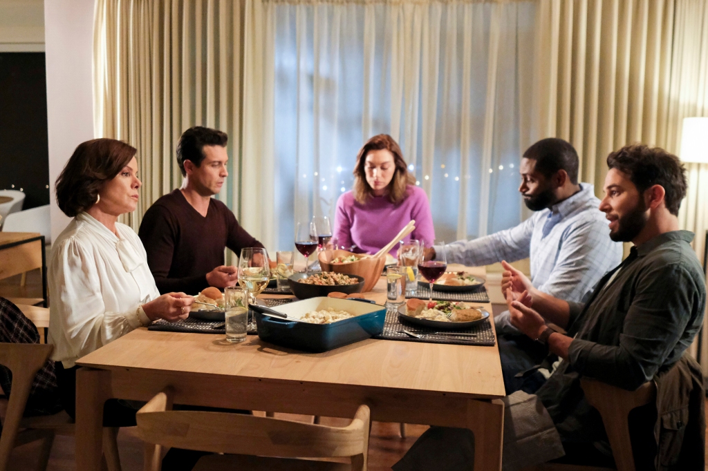 Margaret (Marcia Gay Harden) looks disapprovingly at her son (Sklar Astin), in "So Help Me Todd." They're seated across from each other at the dinner table with four other people.