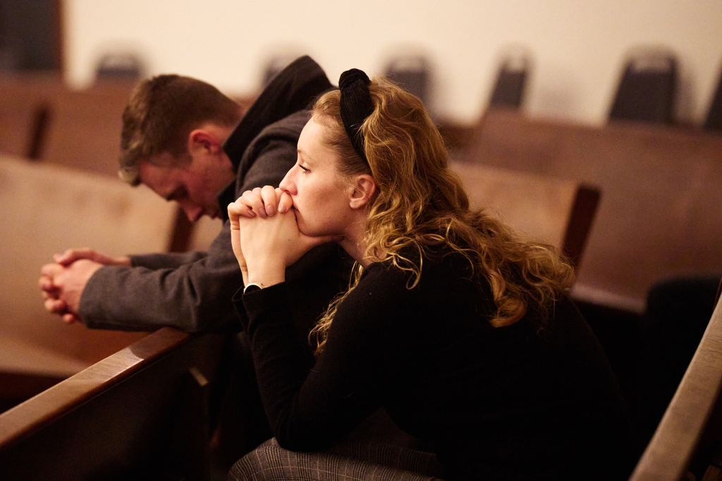 University of Idaho student Sam Kreslins, left, and Washington State University graduate Cecily Parell pray during the service.